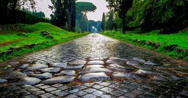 "В типичной римской манере инженеры Империи настаивали на использовании в первую очередь прямых линий для своих дорог и стремились преодолевать препятствия, а не обходить их".

Это потому что римские повозки не имели передней поворотной пары и могли катиться только прямо. Если встречался поворот, то приходилось сгружать поклажу, вручную переставлять повозку и загружать её снова. Бетон, понимаешь, придумали, а поворотную ось в телеге - нет. А зачем, собственно, придумывать? Дорога ведь прямая!