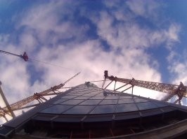 То о чем ты говоришь это мачтовый подъемник (сканлибер), и монтаж стойк-ригель. 
А происходящее на видео, это элементный фасад, так строилась "Лахта" у "вас в Питере", Если ты наблюдал, то при строительстве, кроме башенных кранов невидел там ни каких "лесов" и подъемников. Монтаж происходит с перекрытий зданий.