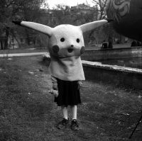 Работа фотографа Александра Чекменёва. Детский аниматор в парке культуры имени Первого Мая, выпивает после рабочего дня (Луганск середина 90-х).

Источник:  © Fishki.net
Это действительно снимок, сделанный Александром Чекменёвым в Луганске, но не в середине 90-х, в 2003. Сам Пикачу-то только в 1996 появился.
На самом деле это целая серия фотографий с интересным продолжением. Вот что рассказывает про эти снимки сам автор: 
"Это Луганск. Парк культуры и отдыха имени Первого мая. Там встретил знакомого фотографа, с ним товарищ в костюме Покемона   дети с ним фотографировались. Уже вечер, решили выпить коньячку. Разлили по пластиковым колбочкам из-под фотоплёнки, этот товарищ только голову снял, и тут девочка подошла   попросила с Покемоном её снять. Взяла эту голову и надела на себя. Мы это увидели и замолчали   какой-то особенный, печальный был момент."
И спустя 18 лет после того как были сделаны фотографии Чекменёв решил разыскать ту самую девочку:
"Известный украинский фотограф, автор книги “Donbass” Александр Чекменёв объявил в соцсетях о поиске героини своего снимка "Покемон". Он ищет девочку, которая сфотографировалась 18 лет назад в Парке 1 мая Луганска, но так и не забрала фото.
Фотограф разместил объявления о поиске в соцсетях, где рассказал историю снимка.
“Эта история произошла со мной в 2003 году в Луганске, откуда я родом. В Парке 1-го Мая я встретил друзей-фотографов, один из которых отработал свой съёмочный день в одежде сказочного персонажа. Решили, что больше съёмок не будет, и взяли бутылочку, на туловище чудо-персонажа поставили пластмассовые стаканчики и налили по первой”,   рассказывает Александр.
Тем временем, к фотографам подошла девочка и попросила сфотографироваться с мультяшным персонажем."