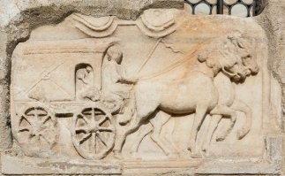 Но ведь нашли эту телегу не в таком замечательном виде, правда же? Скорее всего за 2-2,5 тысячи лет от реальной телеги остались лишь какие-то детали. В раскопе она выглядела в лучшем случае как на фото № 1. А скорее всего, намного хуже. Данная красивая конструкция - это представление наших современников, этакий исторический фейк, скорее всего. 
Но даже если такая конструкция имела место в реальности, я сильно сомневаюсь, что она:
а) была распространённой;
б) была римской (римляне появились в Германии лет шестьсот спустя);
в) использовалась для грузовых перевозок.

Наиболее распространённой в Римской империи была повозка с массивным несущим кузовом, к которому крепились неповоротные оси. На осях монтировались независимые (то есть вращавшиеся каждое само по себе) колёса. Об этом мы знаем в том числе из римских барельефов (фото  № 2 и № 3). Реконструкция такой повозки представлена на фото № 4.
Шкворень (передняя поворотная ось) был изобретён уже в Европе, в раннем Средневековье, предположительно в 7-8 вв н.э.