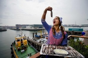 Последнее фото-это не "перекус маринованной сельдю", это ежегодный праздник, который проводится по всем Нидерландам во вторую субботу июня, день селедки.Селедка свежегл улова, малосольная(1 неделя в рассоле) в этот день съедается на улицах в огромном количестве, причем характерным способом. Филейку надо обмакнуть в лук или специи, поднять над головой, затем задрать голову и опусть рыбку в рот. Забавно и действительно очень вкусно!