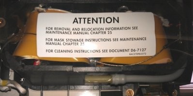 Boeing-737 NG
В верхней и нижней (по фото) частях PSU находятся отсеки кислородных масок пассажиров.
Кислород в маски поступает по серому шлангу, виден с правой стороны.

Кислород к ним поступает из химических генераторов. Металлический цилиндр на фото. Это и есть Oxygen generator. По одному такому генератору приходится на каждый двойной или тройной блок кресел.

Генератор вырабатывает кислород в результате химической реакции хлората натрия с железом, и остановить его невозможно.
Длительность его работы порядка 15 минут. Во время работы генератор нагревается до температуры порядка 230 градусов. Оранжевая полоска на корпусе генератора чернеет при нагреве и показывает, что генератор использован.

В левой части генератора видно устройство его запуска.

Принцип тут примерно как у ручной гранаты - есть подпружиненый боёк, который удерживается небольшим штырём.
Как только штырь вытащен, боёк ударяет в запал и таким образом инициирует химическую реакцию.
Штырь вытаскивается только чисто механически, никакого электропривода нету.
Тросик от штыря через систему колёсиков соединяется с верёвочками, на которых повисают вывалившиеся кислородные маски: