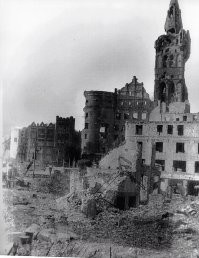 Ну если быть справедливым, то "Нерабочая, аварийная штуковина" (и вправду страшная) стóит не на месте Королевского замка, а рядом. Да и сам замок после английских бомбёжек и нашего штурма выглядел неважно. В первые пару послевоенных десятилетия люди думали где жить, а не как восстановить замковые развалины. Сейчас, когда и время, и технологии иные, иные и рассуждения. Так замок выглядел после боёв: