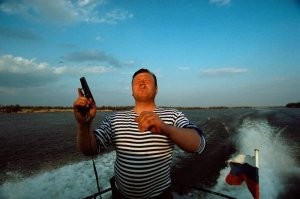 "Инспектор рыбнадзора Олег Ярченко демонстрирует свое оружие. Район дельты Волги, недалеко от деревни Ола, 1997 год."
 А точно не пьяный инспектор шмаляет по чайкам из табельного?
