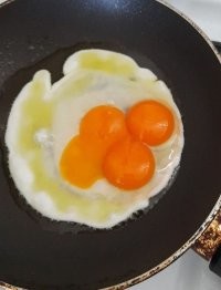 Смахивает на то, что просто 3 яйца разбили на одну сковороду. Как-то подозрительно много белка и желтки нормального размера, хотя, находись они все вместе в одном яйце (даже страусином), были бы куда меньше и спаяны в одну формацию, просто потому что они культивировались в рамках одной скорлупы и волне не волей, деформировались бы друг о дружку, заняв собой большую часть пространства в ущерб количества белка.
А на фото (на мой взгляд), 3-и яйца Д-0 разбили и втриают нам какую-то дичь.