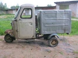 Советский грузовой мотороллер "муравей". Существовала почтовая модификация с закрытой кабиной, но внутри кабины он был вот таким, с мотором под сиденьем.
У французского аналога в кабине ровный пол и двухместная скамья, а мотор - под кузовом. Сидеть удобнее.