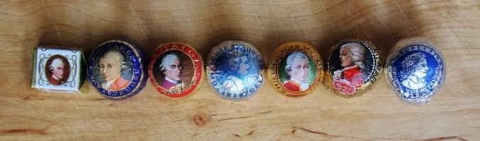 Когда на 12 августа день ВВС России на плакаты лепят американский F-35 - стон и вой стоят на весь интернет.

Иллюстрировать новости про компанию "Salzburg Schokolade" фотками продукции их конкурентов "Mirabell" и "Reber" - ничего, сойдет, "пипл схавает".

Разбираемся с торговыми марками.
1. обанкротилась именно "Salzburg Schokolade", компания и правда не слишком большая, правда сама она моцартовские шарики не продает, есть намеки, что отдает заготовки Mirabell. 
Вот ссылка

Логотип на первой фотке.

2. Шарики делают шесть компаний, самые лучшие и дорогие соответсвенно - ручное производство от изобретателя - "Fürst". Обертка всегда белая с синим портретом.
Вторые - "Holzermayr", тоже бело-синие, на месте стоят 1.1 евро за шарик.
Mirabell четвертые, Reber - пятые.
Вот тут товарищ тестировал 

перевод