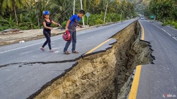 Так то это обычное дело, и легко объяснимо.
Асфальт, чтобы полностью не перекрывать движение, часто кладут по очереди сначала одну полосу, потом другую. И когда, во время землетрясения, земля "плыёт", рвёт именно в слабом месте, вдоль, на стыке двух полос.