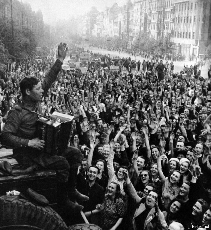 Жители Праги слушают игру русского солдата на гармошке. Прага, Чехия, 9 мая 1945 года.
