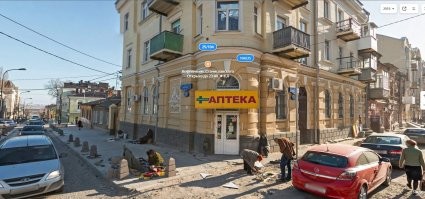 На панораме в 2010 году еще нет этого сплита, а в 2018 установили столбики. Так что фотка сделана между ними. 
Забавно, что ремонт дорогие не мешает гражданам торговать прямо в грязи, на "своем" месте.