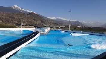 >> A surfer dressed as Santa Claus rides an artificial wave in a 0.6 degree cold water in the Alaia Bay surf wave pool surrounded by Swiss Alps, in Sion. AFP

Это открытый бассейн с искусственными волнами для серферов.
Но была халва при нуле градусов серфить...