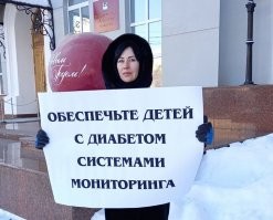 а почему бы ей с таким плакатом не встать перед зеркалом? 
себя вроде шубой обеспечила...