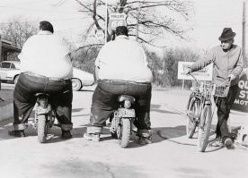 На первой фотографии братья-близнецы Билли и Бенни МакКрэри. Их общий вес более 650 кг. 

Билли и Бенни МакКрэри отличились огромным весом, но причиной стала вполне себе безобидная детская болячка, которую сотни тысяч детей переносят с легкостью и без каких-либо последствий. Но у них получилось иначе, хворь дала осложнение на гипофиз, который стал без устали синтезировать гормон роста, но росли парни почему-то только вширь. 

Родившись вполне обычными малышами с весом чуть больше двух кило, до 4 лет они были как все детки и тут последствия проявили себя - вес парни начал расти. Уже к средней школе мальчишки были весьма упитаны - вес каждого из них превышал отметку в 90 кг, что удивительно, парни оставались подвижными и весьма шустрыми, но масса тела продолжала расти. Обращения к специалистам также, как и физический труд, присутствующий в жизни Бенни и Билли в избытке, результатов не дали - мальчишки толстели. Родители не прекращали искать способ, способный заставить парней сбросить вес, но дело было в начале 50-х прошлого века, так что ничего нового им не подсказали. 

Несмотря на то, что вес стремительно рос, парни продолжали "активничать" - сначала гоняли на великах, а когда подросли, пересели на мотоциклы. Железные кони смотрелись под массивными телами как игрушечные трехколесные велосипеды. Компания Хонда, завидев таких крупных парней, с легкостью раскатывающих на их мотоциклах, предложила братьям контракт - они следуют из Нью-Йорка до Лос-Анджелеса, не меняя железных коней и не делая капремонта. Все время марафона шла прямая трансляция их пути, сотни тысяч глаз наблюдали за братьями по телевизору. Стоит ли говорить о том, насколько подскочили продажи авто- и мототехники после удачного финиша? 

Несмотря на активную жизнь, вес братьев рос, уже к 30 годам они весили за 200 кг каждый, и это не было пределом. Парни стали рекордсмена книги рекордов Гиннесса как самые тяжелые близнецы. Максимальный суммарный вес мужчин достиг отметки в 665 кг – 328 и 337 кг. Но и такой вес не стал преградой на пути к новому увлечению – братья решили заняться армрестлингом. Десятки выигранных боев и слава по всем соединенным штатам. 

На сегодняшний день ни одного из братьев уже нет с нами, но память о них жива. Они занесены в книгу рекордов Гиннеса как самые тяжелые близнецы, а в память людей как неуемные байкеры. Среди спортсменов они считаются непобедимыми, хоть и самыми тяжелыми армрестлерами. 

К сожалению, их медийные подвиги на двух колесах в конце концов завершились падением Билли. В июле 1979 года, в возрасте 32 лет, он умер от травм, полученных во время трюка на мотоцикле на Ниагарском водопаде. Бенни пережил своего брата почти на 22 года и продолжил карьеру борца. А скончался от сердечной недостаточности в 2001 году в возрасте 54 лет.