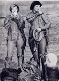 Ну какой жир?, зачем? - в гермошлеме и костюме с таких высот прыгают.
Просто губы красит - обычное дело для тётеньки, и обстановка не имеет значения.