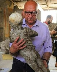 "Археолог и ребенок из Помпей"

Не ребенок, а пластиковая отливка ребенка.
От засыпанного горячим пеплом тела остается полость, которую заливают застывающим раствором и потом достают отливку.