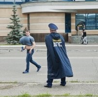 Абсолютно ничего странного тут нет. Просто чувак с пересёк двойную сплошную с непонятным напитком в руке и его тормозит ДПС-бэтмэн в плаще. Будет выяснять, почему почему выступающие за габариты буфера не обозначены соответствующими знаками.