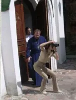 Первое фото, когда сотона попал в кадр. Он позади священника и нашептывает шлепнуть по попе девицу.