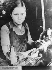Блокадная Джоконда. Вера Тихова, 15-летний токарь.
Автор фото: Василий Федосеев, 1943 год.
Во время блокады она работала на заводе, который находится на Петроградской стороне. Здесь, на токарном станке, который привык к мужской силе, она вытачивала детали для снарядов, выдавала по полторы взрослые нормы и даже стала токарем 3-го разряда. Василий Федосеев просто не смог не сфотографировать молодую и красивую девушку с загадочным взглядом и сдержанной полуулыбкой. Фотографию увидели только после войны на одной из послеблокадных выставок. К снимку тут же прикрепилось название Блокадной Джоконды, потому что Вера Тихова, которая на секунду оторвалась от производства, необычайно похожа на ту самую Мону Лизу великого художника Леонардо да Винчи.