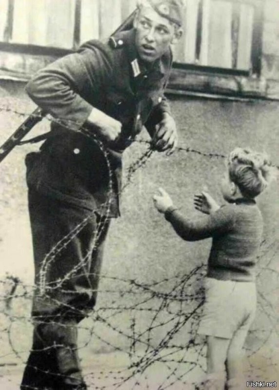 Немецкий солдат помогает маленькому мальчику перебраться через Берлинскую стену, 1961 год
Я думаю будет правильней написать "Солдат ГДР....."