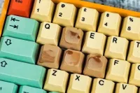 Тут скорее обыграли шутки про задротов, а не пролитый кофе. Эти клавиши часто стерты у геймеров.