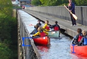 >>> Главное - не раскачиваться

Главное - не взлетать, а раскачиваться можно. Высота от уровня воды до обреза акведука - сантиметров 50. Если не вставать в рост (не знаю людей, встающих на воде в каяке), то перевалиться вниз невозможно в принципе.
Хотя, вон там дядька с веслом стоит. Думаю, специально для опускания на место пытающихся встать ))))