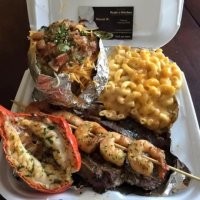 Простейший поиск по картинке даёт нам полный её вариант, на котором видна этикетка с надписью Orsie's Kitshen или что-то в этом роде, первое слово не читается полностью, зато второе видно отчётливо. Ниже Mareel W. и ещё что-то рядом, причём в последнем слове угадывается слово Chef. Нетрудно сообразить, что этот самый Mareel W. -- шеф-повар. А в целом же, по виду блюда в пластиковом контейнере и фольге, мы имеем дело с каким-нибудь уличным ресторанчиком, работающим на вынос.
Вот и вся тайна "израильского школьного обеда"