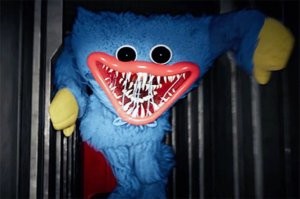 Это персонаж из прошлогодней игры-бродилки в стиле ужасов. По сюжету на заброшенной фабрике игрушек одна из кукол, изначально предназначенная для обниманий (от англ. Hug - обнимать, отсюда и имя Huggy Waggy) оживает, становится злой и гоняется за игроком.

Этот персонаж в начале 2022 года был обыгран всевозможными ютуб-недоблоггерами и тиктокерами. Ну а потом продавцы сувениров тоже решили клювом не щелкать, а зарабатывать, пока этих кукол покупают.