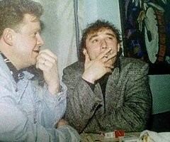 Просто на Пикабу после этой фотографии шла действительно вот эта фотка Фоменко. Автор слишком быстро копировал и перепутал. На Пикабу кстати первая фотка подписана - "На концерте группы "С.Т.Д.К." на рынке "Юнона" в Санкт-Петербурге, 1998 год".
Как-то так. Ребус решён.