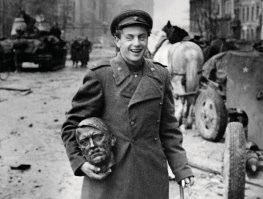 Берлин, май 1945.
Тросточка в левой руке - не пижонство. В Сталинграде батальонный комиссар Долматовский был ранен в ногу, из-за чего остался хромым на всю жизнь.