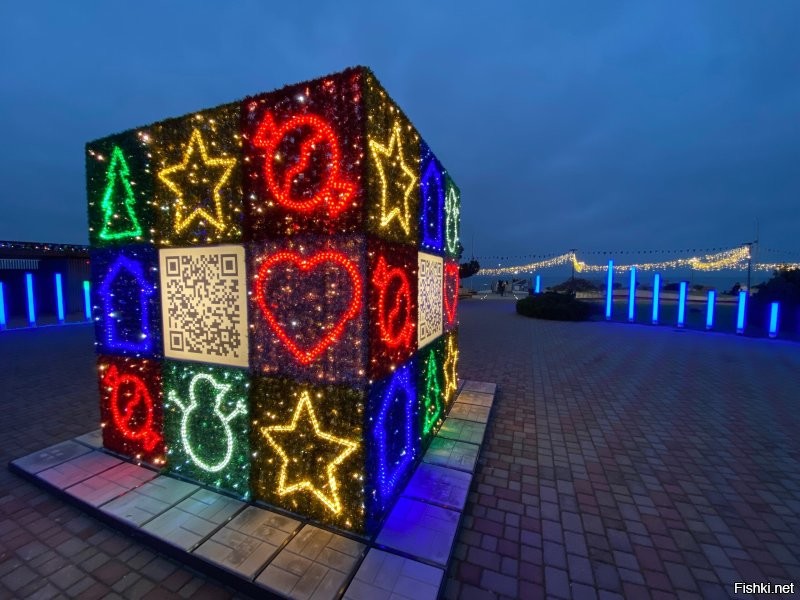 Не нахожу прямо возмутительным решение украшать и тратить на это. Меня поражает тупизна того кто вообще придумал одежду развешивать на центральных улицах. Ну ладно бы возле, на, или даже внутри торговых центров, где одежду продают. Тут как раз это уместно, весело и симпатично. Но поперёк больших улиц... Это надо реально полагать, что бельё над дорогами, это интересный штрих и достойно воплощения в новогодней гирлянде в центре городских улиц. Вкус "дизайнеров"  которые краше сараев ничего не видели.
 Вот наш маленький по сравнению с Сочи тоже курортный городок. Практически все украшения с прошлого года. Добавили только указатели и куб. Многие украшения города - это частная инициатива владельцев магазинов. Но каков эффект! Гости, да и мы местные заполняем свои облачные хранилища фотками этой красотищи. Приезжие чуть не писаются от восторга. На мой взгляд это куда как симпатичнее и уместнее развешанной светящейся одежды, тем более трусов.