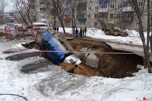 Канализация? На глубине 100 метров? Серьезно?

Карстовые провалы не имеют отношения к канализации. Не, она, конечно, может добавить скорости образованию воронок, но уж точно не является причиной. Причина - грунтовые воды. И борьба с ними стоит на порядок дороже, если вообще возможна.

Вот провал от канализации, разница видна сразу: