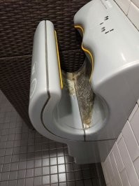 Это сушилка Dyson Airblade. Я не очень представляю что нужно делать, чтобы она была в таком виде. Там пластик с гидрофобным покрытием. Скорее всего она просто подгорела по каким-то причинам.