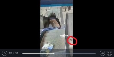 На 0:18 сотрудник службы безопасности. Никуда не спешащий. И рядом с ним, возле поручня – что это? 
Если не путаю, в верхней и в нижней частях эскалатора всегда были (раньше, по крайней мере) выключатели, которыми можно было остановить эскалатор. Это не он?