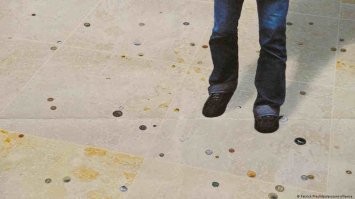 Про монеты на полу.

"Художники Чиска Богман (Cisca Bogman) и Оливер Штёрмер (Oliver Störmer) украсили пол в зале прилетов монетами из разных стран. Их идея проста: каждый прибывший пассажир должен почувствовать себя как дома, когда увидит, так сказать, родные деньги."