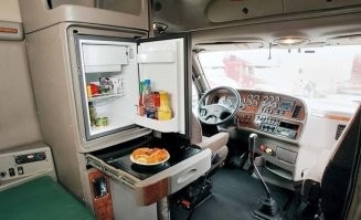 Любит он его, хочет чтоб питался в дальнем рейсе нормально, а не в придорожных рыгаловках язву зарабатывал..  Вот и собрала ему хавку по царски.  Это вам не два бутерброда сделать и в термос чая налить.  А с  холодильником проблем в машине не будет, ибо есть как мобильные решения, так даже в некоторых авто их встраивают с завода, понимая что вещь человеку - нужная.  
Приятного ему аппетита, надеюсь заработает денег - купит жене какую-нить обновку :) И будут они жить счастливо.