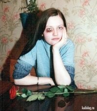 Штош, дорогой Холмс...
Девушка ещё молода, и вполне себе ещё может не быть замужем, в наше то время. И может носить кольцо на безымянном пальце левой руки просто для красоты. 
Фото явно постановочное, фингал под глазом нарисованный. Тут не надо быть врачом-травмотологом, чтобы увидеть, что глаз совсем не опух, как это обычно бывает после удара по глазу. А цветок на стол положил композитор этой постановки, он же фотограф. И тут Вы правы - цветок он держал в правой руки, и положил его на стол, находясь напротив объекта съёмки. Поэтому бутон цветка лежит с левой стороны.
Левша. =)