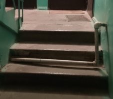 Мдяя.. действительно тупое решение. 
Что мешало при наличии перфоратора сделать отверстие в лестнице возле стены и пустить трубу снизу? Конечно, тоже не идеально,но лучше, чем на фото.