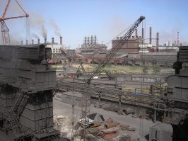 Кокс имеет некоторый блеск(особенно игольчатый),поэтому может казаться,что имеет серый оттенок.Однако, измельченный кокс дает радикальный черный цвет. 
Если че, серый цвет имеет графит.
 Для примера - цех,где перерабатывается кокс.