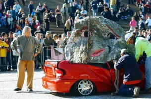 Серия арт-инсталляций чувака Jimmie Durham.
Я нашёл в Сети около пяти-шести.
Все машины, как видно, стоят аккуратненько, зачастую  в границах парковочного места, и вокруг нет ни осколков, ни обломков.