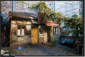 Ты видимо провел всю свою жизнь в хрущевке, в спальном районе и просто представить себе не можешь другие варианты.
Представь, попробуй: тихий центр столицы одной из союзных республик. Старинные  одно-двух этажные дома граничат с большими современными зданиями, образуя удивительные дворики.
Это не фотография именно того дома, но суть она передает верно.