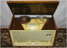 На даче у меня такая радиола стоит. 
Сосед, рукастый парень всю начинку поменял. По сути целый комп внутрь установил. 
Катушки крутятся для вида.
Главное то, что динамики там стоят его родные, бархатный звук такой.
Фото не мое, для сравнения.