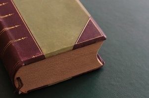 Тетради, из коих книга состоит, тянут переплет и в конце концов он просядет. Переплет должен быть выпуклый, прижатый к корешку, а пакет тетрадей по внешней стороне с небольшой "канавкой" или плоский, не выходящий за габарит обложки (правильнее - крышки).