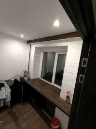 Отдолбил 4 см старой советской ужасной штукатурки до кирпича. Получилось 4 строительных мешка мусора. Сын сказал что это круто и было решено оставить кирпич. 
Чуть подмазал шпатлевкой для наведения красоты. 300р. 
Подоконник - сосна 40 мм. Выбрали самую страшную и пеструю.  4500р
Верхушка это не элемент дизайна а необходимость. Там гипсокартоновый короб и тонкий 10 мм мебельный щит из леруа. 700р. 
Вывел пару розеток, их не видно, они на правом откосе. 
Подоконник с боков опирается на прикрученные к стенам брусы 40х40. 0р. 
Самым дорогим оказались тумбочки которые будут по бокам. 
Их на фото еще нет, но обошлись в 10.000 примерно. 
Рулонная штора 4500. 
В общем, пока может показаться не супер, но я то уже знаю каким будет результат))) Потому и уверен, что будет прикольно.