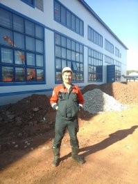 Вы на вахте бывали? Оранжевые каски носят рабочие, не зависимо от национальности. Электрики только некоторые в синих ходят. 
А белые каски носят ИТР - старший инженер, нач. участка, прорабы, мастера, бухгалтерия, кадры.
Мне на вахте довелось и разнорабом поработать, в оранжевой каске, и мастером - в белой.