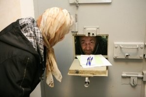 Дверь  то картонная... 
Сразу бы с "кормушкой"  поставили. Открыли и посмотрели в случае чего....