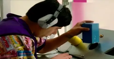 Девушка пытается повесить разводной ключ на стену