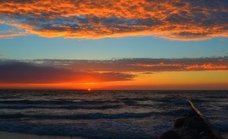 Не исключаю что на фото присутствуют фильтры. Однако ваш вопрос странный. ГДЕ розовый цвет должен быть на домах и деревьях, если рассветное фото показывает только небо, тучи, море, песок и волнорезы? Домов и деревьев там нет. А фото с закатом розового не имеет. И на деревьях нет никакого оттенка, потому что они освещены сзади и могут быть лишь тёмные, почти черные. На здании нет отблеска, поскольку уже включена подсветка и она очень сильно меняет цветность стен. Тут я уверена что фото вполне натуральное. Ну может лишь чуть усилено небо по цвету, хотя видела вживую такую интенсивность. Наши закаты реально невероятные по сочности красок.  Не зря называют их янтарными. Вот ещё примеры. В принципе тут и фильтры не особо нужны. Своими глазами все такое можно увидеть каждый день.