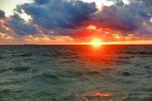 Не исключаю что на фото присутствуют фильтры. Однако ваш вопрос странный. ГДЕ розовый цвет должен быть на домах и деревьях, если рассветное фото показывает только небо, тучи, море, песок и волнорезы? Домов и деревьев там нет. А фото с закатом розового не имеет. И на деревьях нет никакого оттенка, потому что они освещены сзади и могут быть лишь тёмные, почти черные. На здании нет отблеска, поскольку уже включена подсветка и она очень сильно меняет цветность стен. Тут я уверена что фото вполне натуральное. Ну может лишь чуть усилено небо по цвету, хотя видела вживую такую интенсивность. Наши закаты реально невероятные по сочности красок.  Не зря называют их янтарными. Вот ещё примеры. В принципе тут и фильтры не особо нужны. Своими глазами все такое можно увидеть каждый день.