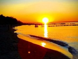 Не исключаю что на фото присутствуют фильтры. Однако ваш вопрос странный. ГДЕ розовый цвет должен быть на домах и деревьях, если рассветное фото показывает только небо, тучи, море, песок и волнорезы? Домов и деревьев там нет. А фото с закатом розового не имеет. И на деревьях нет никакого оттенка, потому что они освещены сзади и могут быть лишь тёмные, почти черные. На здании нет отблеска, поскольку уже включена подсветка и она очень сильно меняет цветность стен. Тут я уверена что фото вполне натуральное. Ну может лишь чуть усилено небо по цвету, хотя видела вживую такую интенсивность. Наши закаты реально невероятные по сочности красок.  Не зря называют их янтарными. Вот ещё примеры. В принципе тут и фильтры не особо нужны. Своими глазами все такое можно увидеть каждый день.