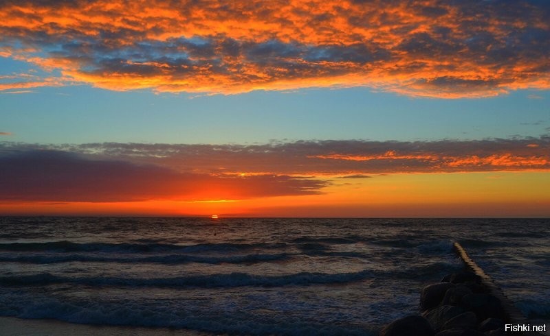 Не исключаю что на фото присутствуют фильтры. Однако ваш вопрос странный. ГДЕ розовый цвет должен быть на домах и деревьях, если рассветное фото показывает только небо, тучи, море, песок и волнорезы? Домов и деревьев там нет. А фото с закатом розового не имеет. И на деревьях нет никакого оттенка, потому что они освещены сзади и могут быть лишь тёмные, почти черные. На здании нет отблеска, поскольку уже включена подсветка и она очень сильно меняет цветность стен. Тут я уверена что фото вполне натуральное. Ну может лишь чуть усилено небо по цвету, хотя видела вживую такую интенсивность. Наши закаты реально невероятные по сочности красок.  Не зря называют их янтарными. Вот ещё примеры. В принципе тут и фильтры не особо нужны. Своими глазами все такое можно увидеть каждый день.